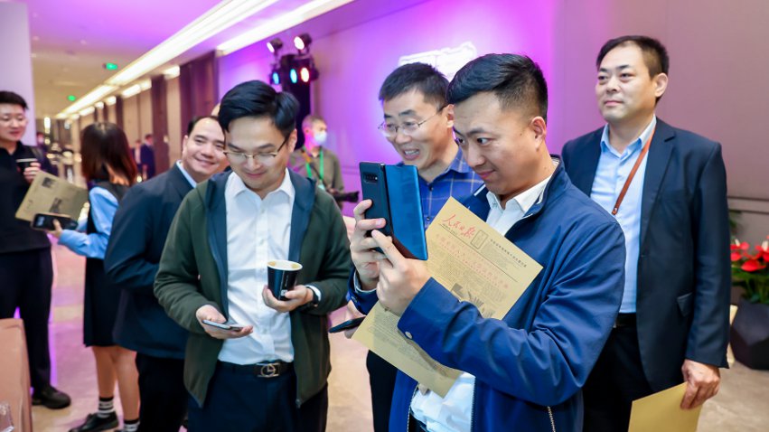 人民網(wǎng)研發(fā)推出的《人民日?qǐng)?bào)》生日?qǐng)?bào)吸引嘉賓體驗(yàn)。主辦方供圖